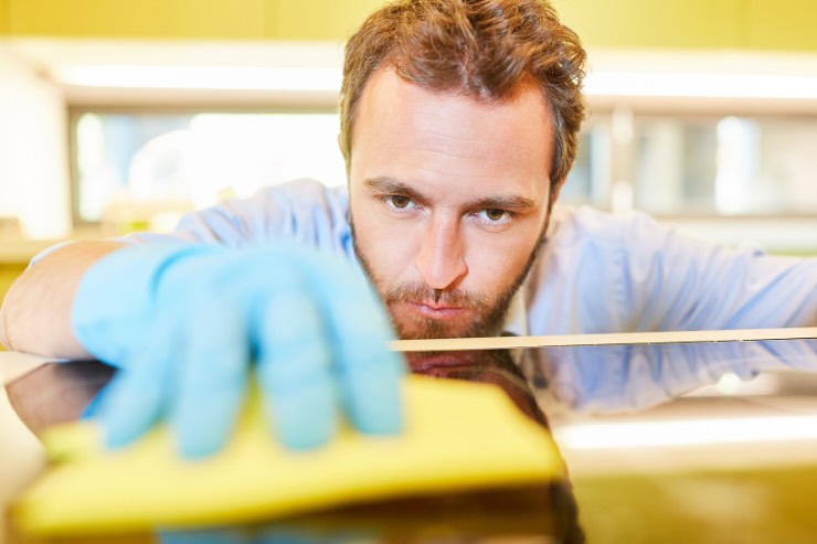 uomo che pulisce piano cottura