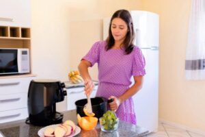donna che cucina con la friggitrice ad aria