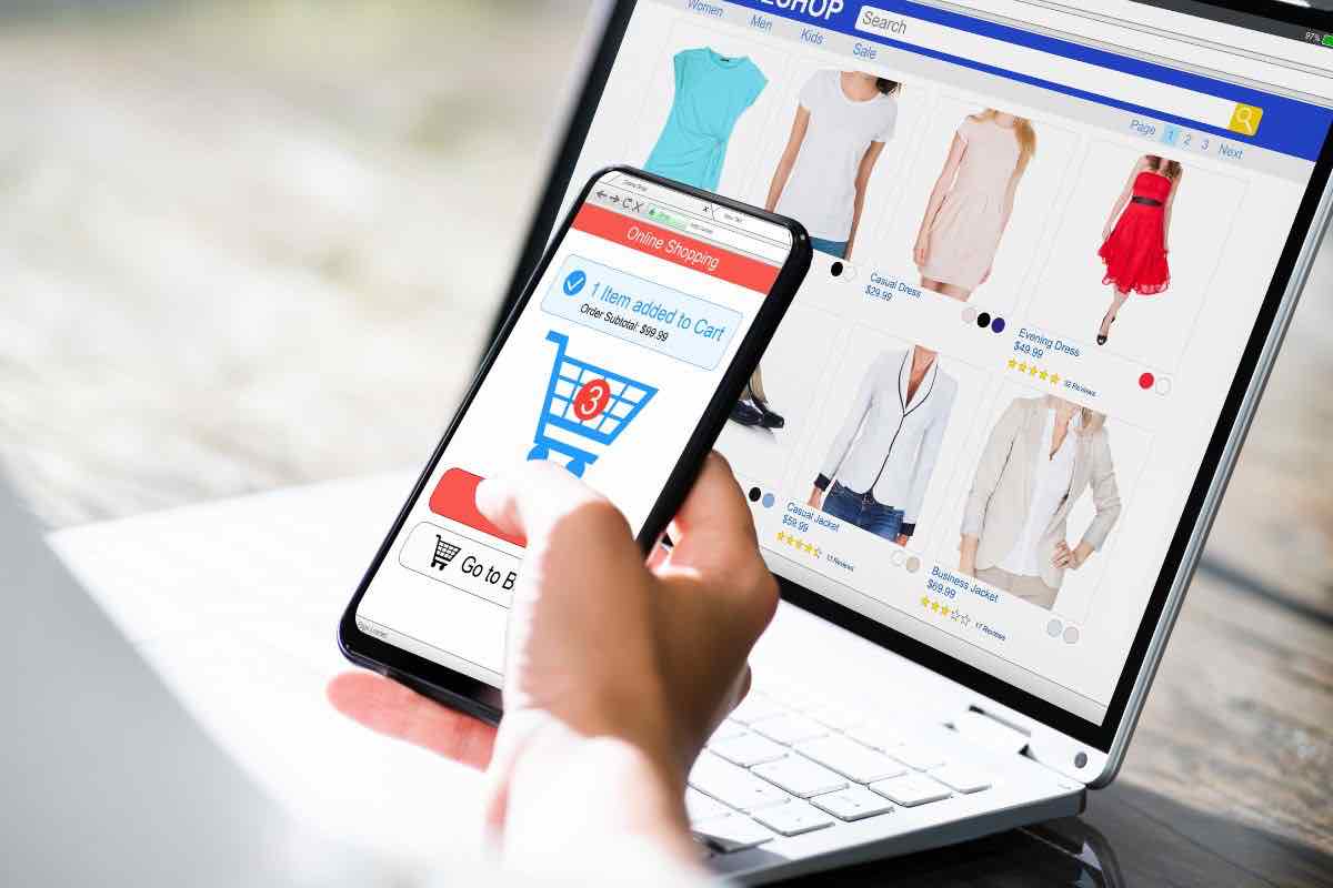 Persona con computer e smartphone in mano