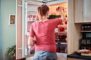 ragazza che apre il frigorifero