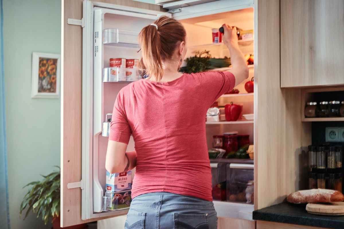 ragazza che apre il frigorifero